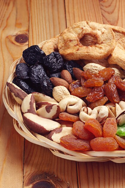 Dried fruits and nuts on a natural wooden background