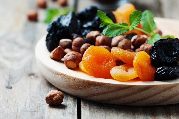 Dried fruits and nuts on wooden plate