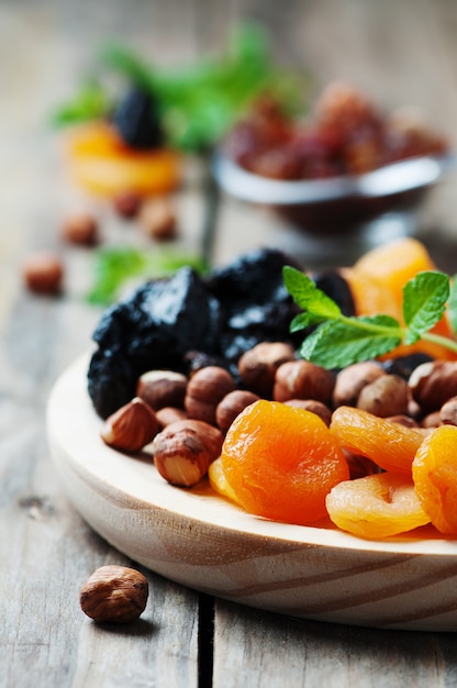 Foto frutta e noci secche sul vassoio di legno