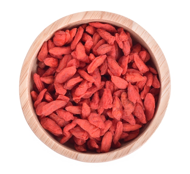 Dried goji berries in a wooden bowl isolated.