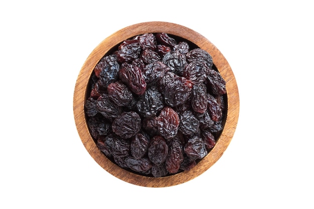 Dried grapes dark raisins in wooden bowl isolated on white background Vegan food top view