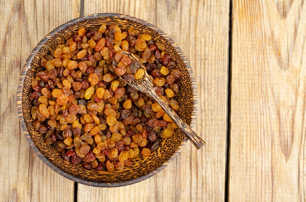 Dried grapes and raisins in wooden bowl