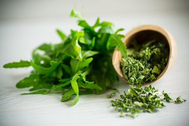 Dried green organic arugula seasoning on a light background