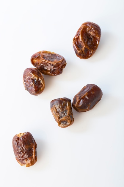 Dried halawi dates on a white