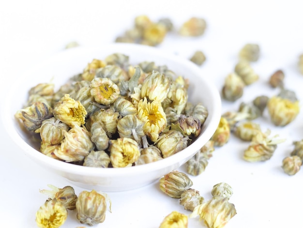 Dried herbs baby crysanthemum flower bud in bowl on isolated white background