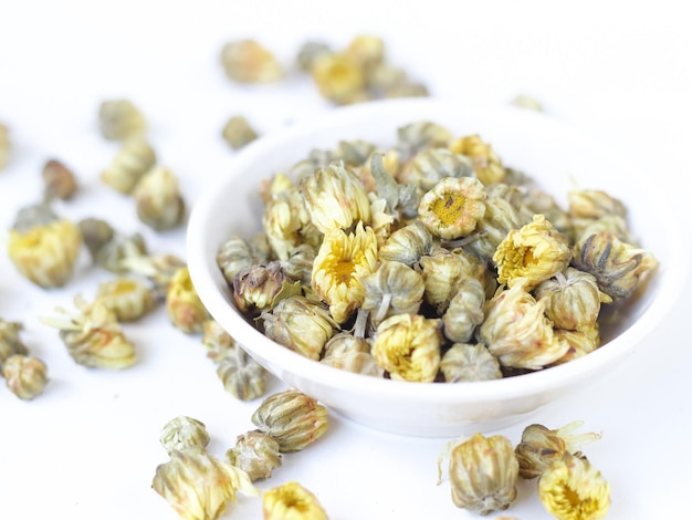 Dried herbs baby crysanthemum flower bud in bowl on isolated white background