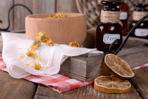 Dried herbs and bottles with tinctures on table close up