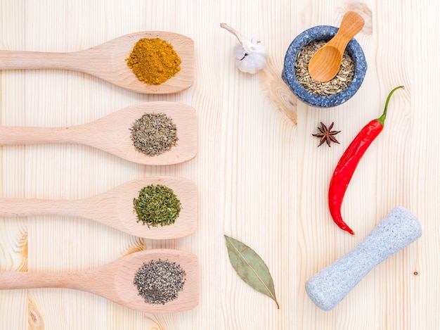 Dried herbs and spices on wooden table with copy space.