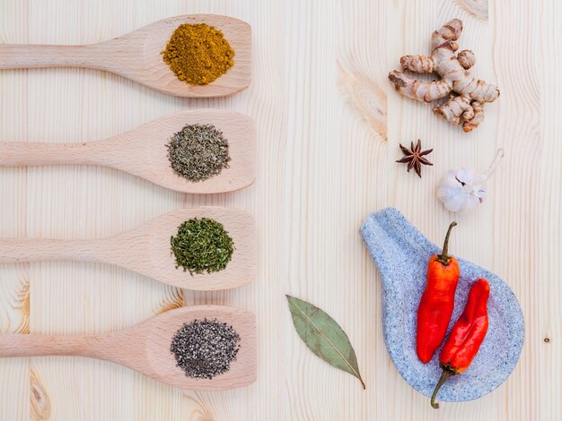 Dried herbs and spices on wooden table with copy space.