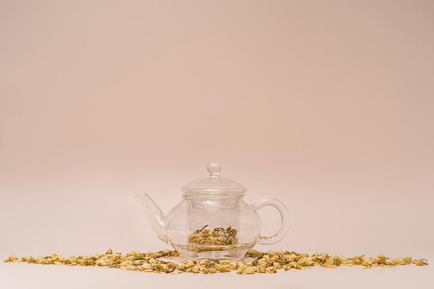 dried jasmine flowers in a teapot on a pink background flower tea