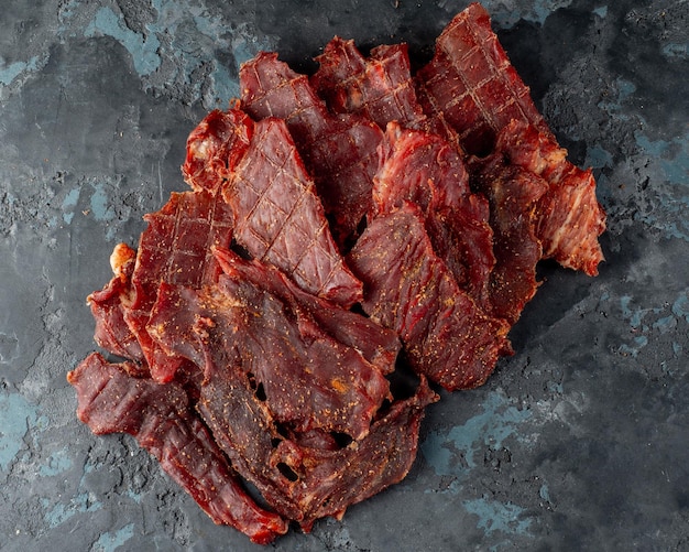 Photo dried jerky pork meat on a dark background