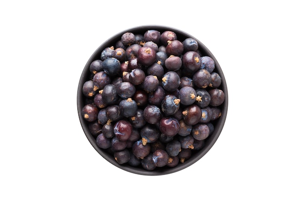Dried juniper berries in clay bowl isolated on white background Seasoning or spice top view