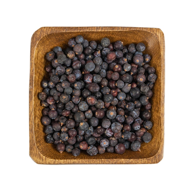 Dried juniper berries in wooden bowl isolated on white background Top view