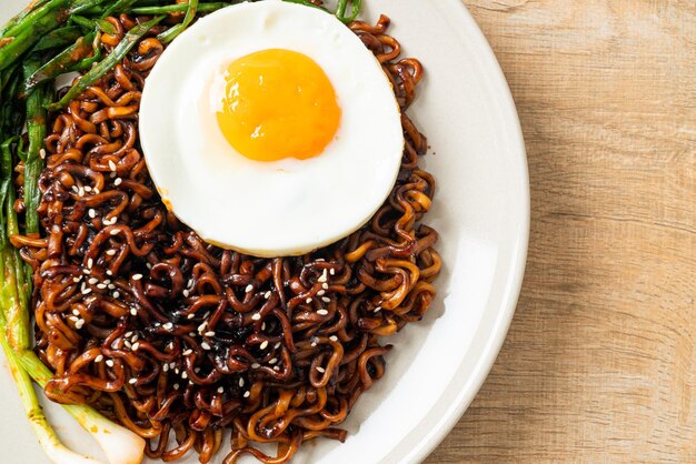Dried Korean spicy black sauce instant noodles with fried egg and kimchi