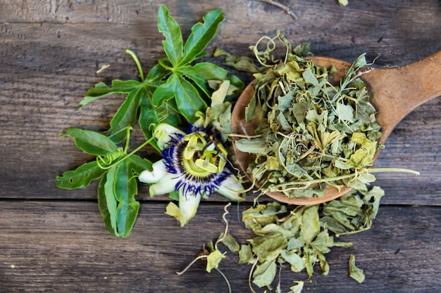 木の背景に鎮静茶を飲むためにトケイソウの葉を乾燥させた