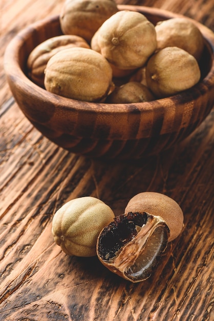 Dried limes on wooden table. Whole and crushed fruit