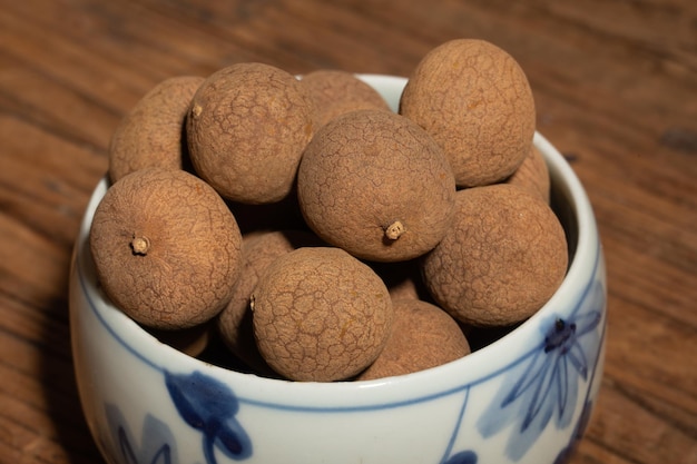 Dried longan in the container on the wood grain table