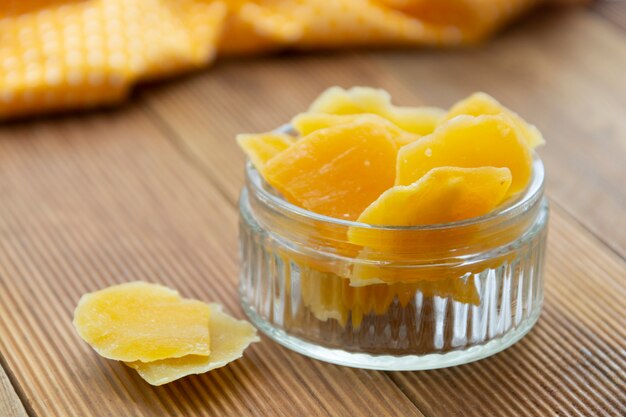 Dried mango in glass bowl on wooden background