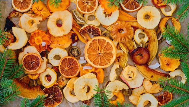 Dried mixed fruits on paper table, top view. Delicious gift, decorated with branches of Christmas tree. The idea of breakfast, healthy snack. Healthy eating concept or extraction to food