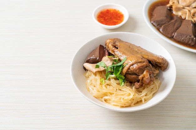 Dried noodles with braised duck in white bowl