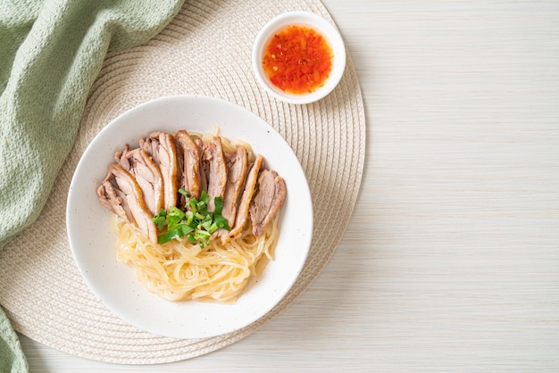 Dried noodles with stewed duck in white bowl