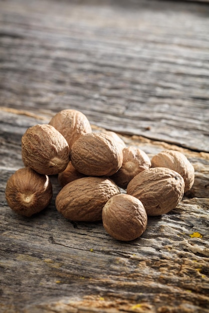 Dried nutmeg seeds set on old wooden surface