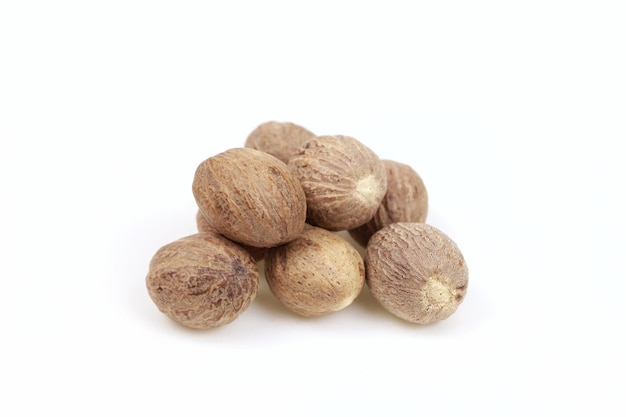 Dried nutmeg seeds on white background