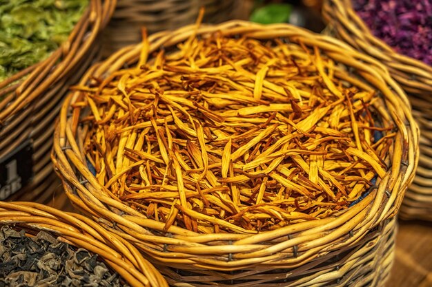 Photo dried orange lily flower stems in traditional basket