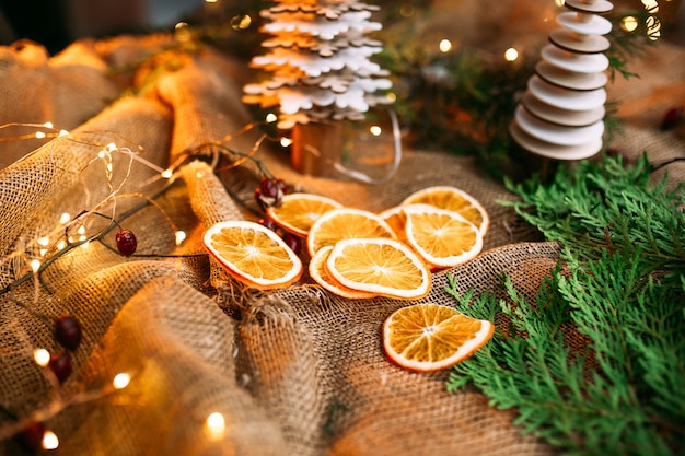 Dried orange slices on the sackcloth with garland and spruce branches