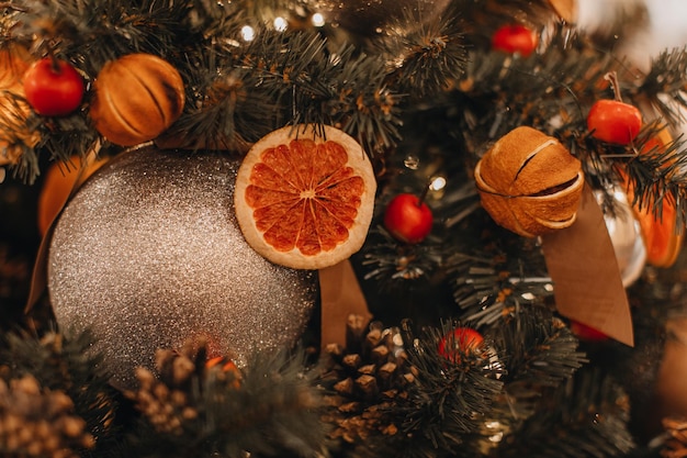 Dried oranges berries cones hanging on the Christmas tree Creative festive details