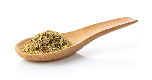 Dried oregano in wood spoon on white