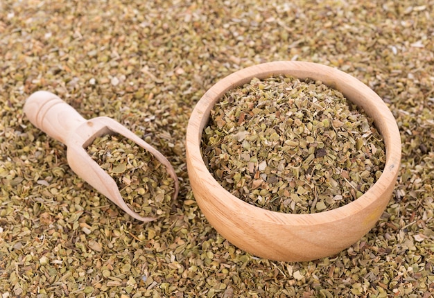 Dried Oregano on wooden bowl background