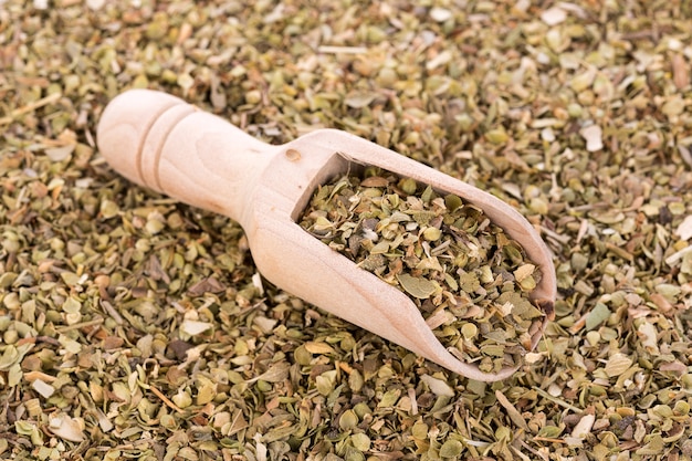 Dried Oregano on wooden spoon background