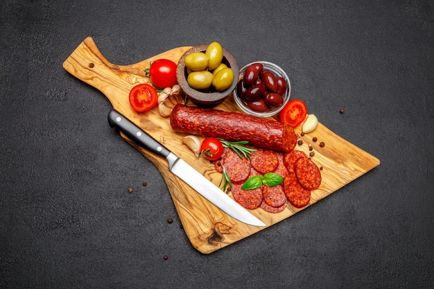 Dried organic salami sausage or chorizo on wooden cutting board