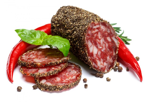 Dried organic salami sausage covered with pepper on white isolated