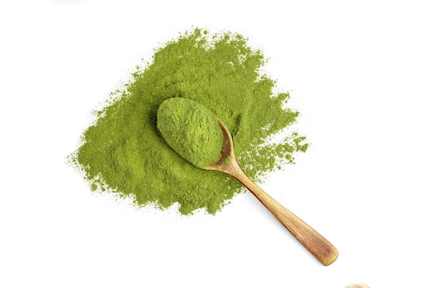 Dried organic wheatgrass powder in wooden spoon isolated on white