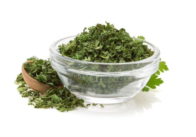 Dried parsley in bowl isolated on white 