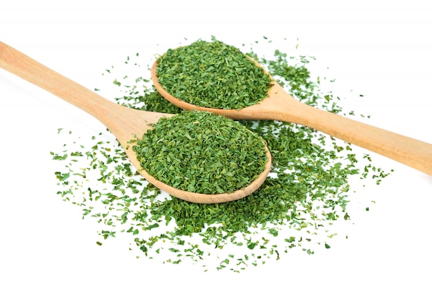 Dried parsley in wood spoon isolated