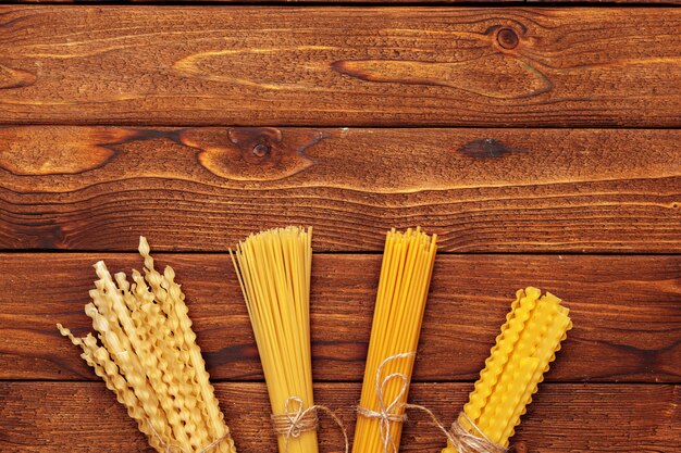 Dried pasta on wooden background