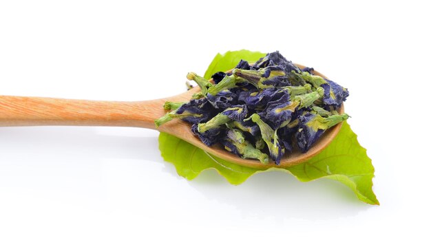 Dried pea flower in wood spoon on white background