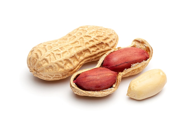 Dried peanuts in peel closeup isolated on white background.