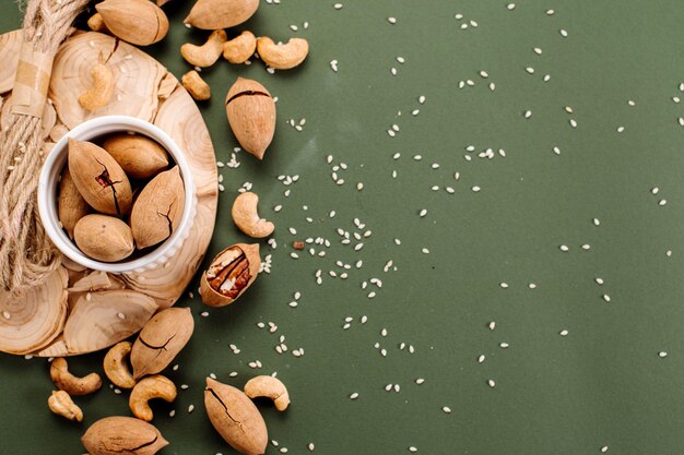 Dried pecans scattered on a green background