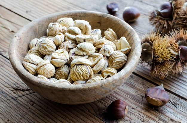 Foto castagne secche sbucciate su fondo di legno