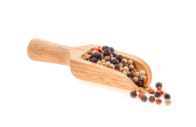 Dried peppers in wood scoop isolated on white