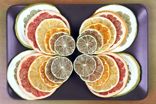 Photo dried pieces of citrus fruit on a plate. useful vitamin food of fruit