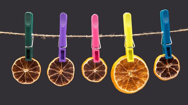 Dried pieces of citrus fruits hang on clothespins