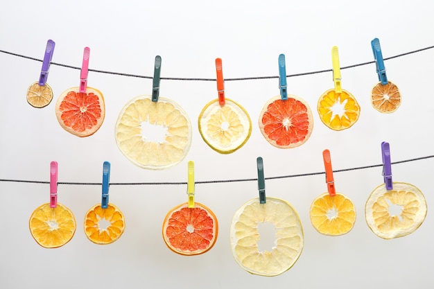 Dried pieces of citrus fruits hang on clothespins