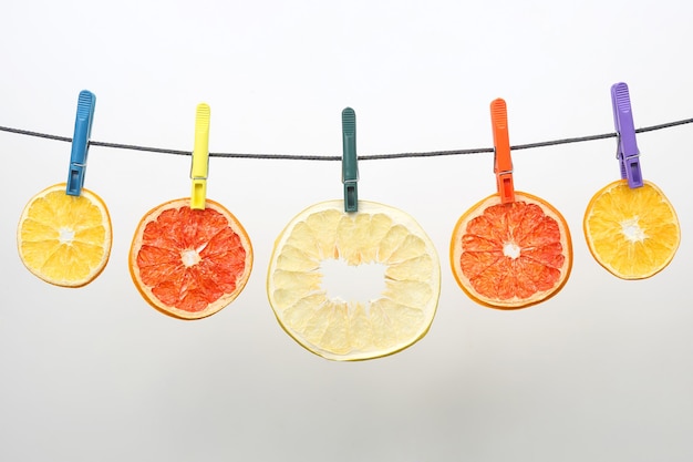 Dried pieces of citrus fruits hang on clothespins