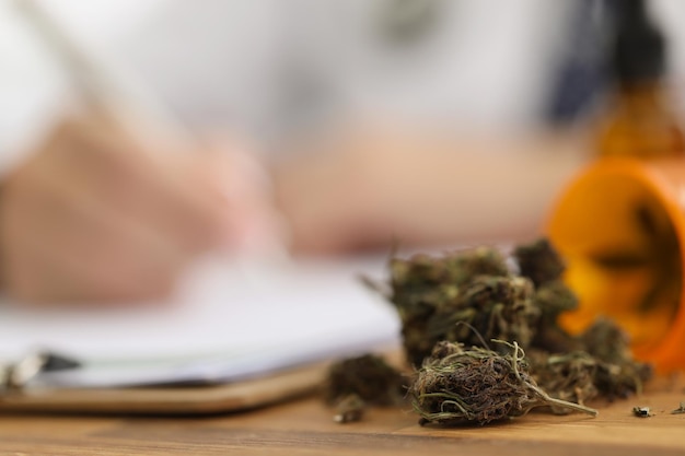 Photo dried pieces of marijuana on doctors desk fell out of plastic bottle