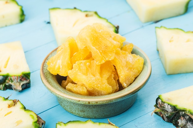 Photo dried pineapple in the bowl on wood wall